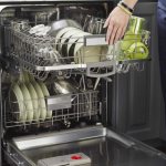 Полная загрузка посуды в полноразмерную двухярусную посудомоечную машину на кухне